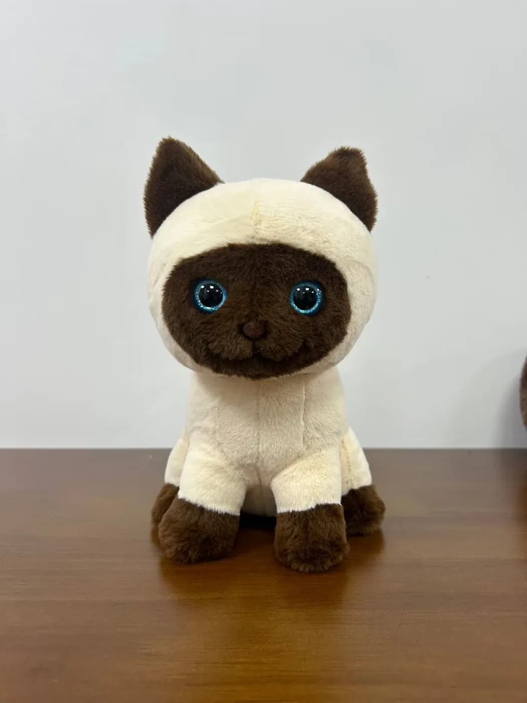 Siamese cat plush toy with embroidered blue eyes and a soft hood