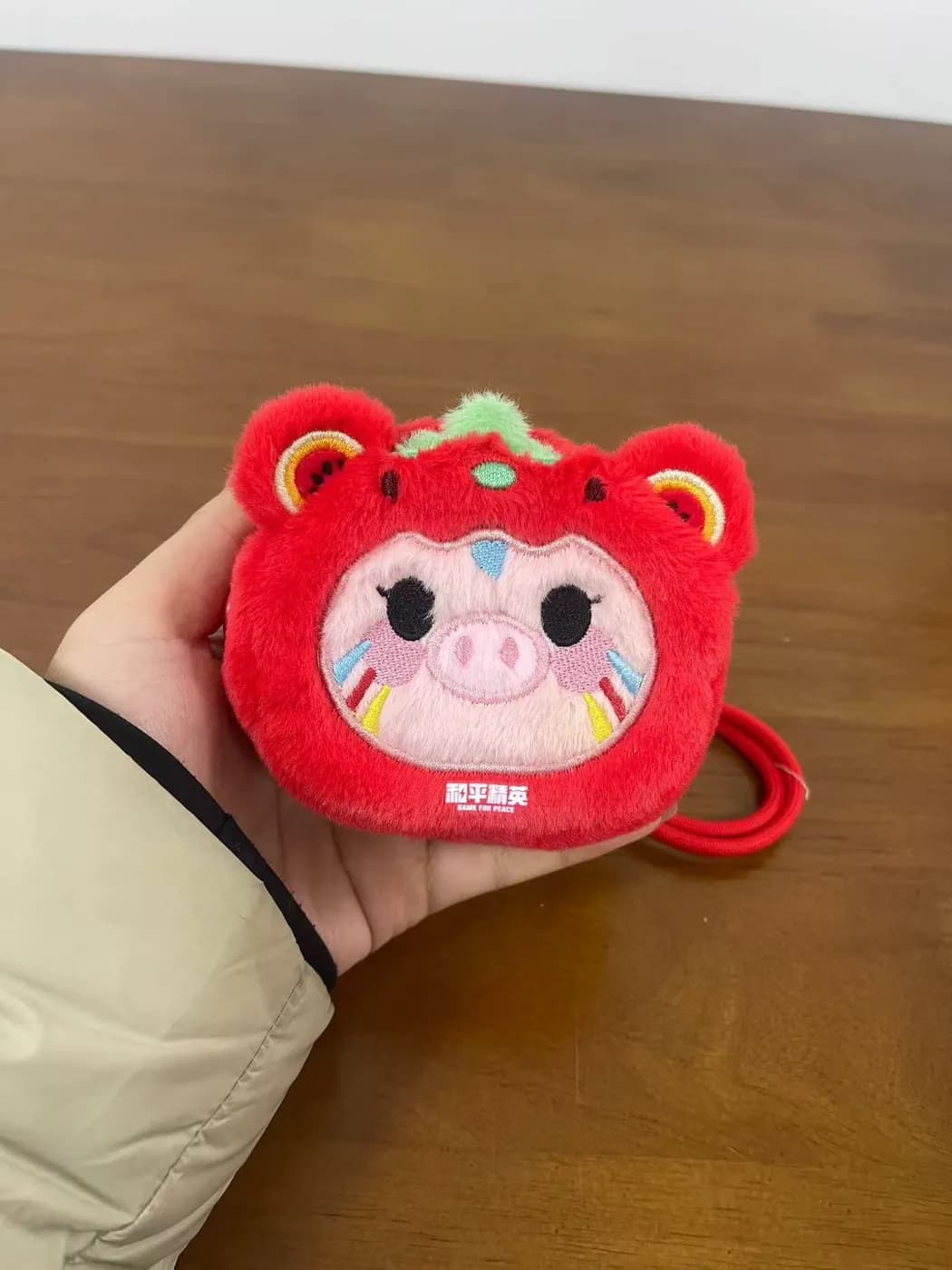 Red bear-face plush coin purse keychain with a printed panel